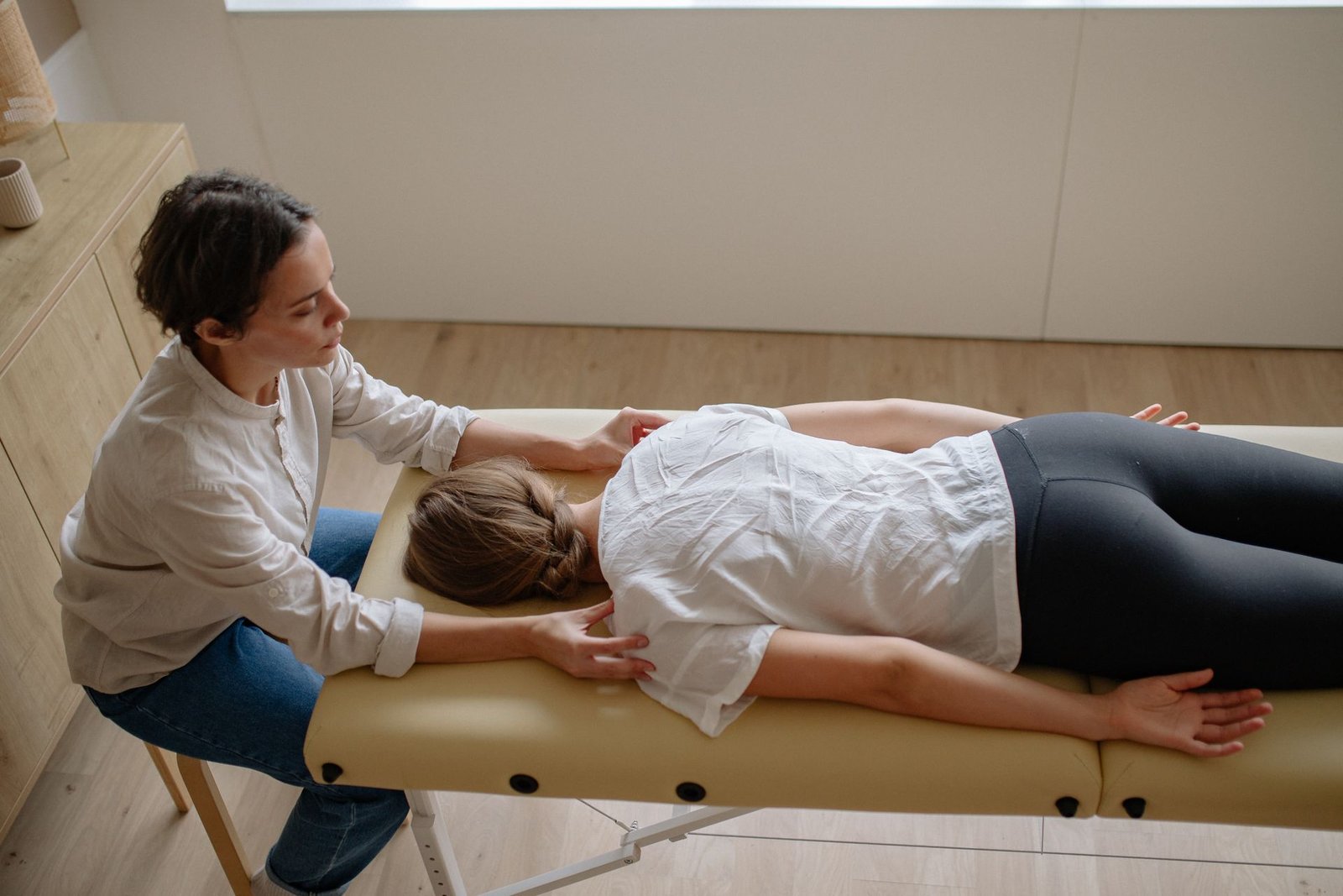A chiropractor treating a patient lying on a treatment table