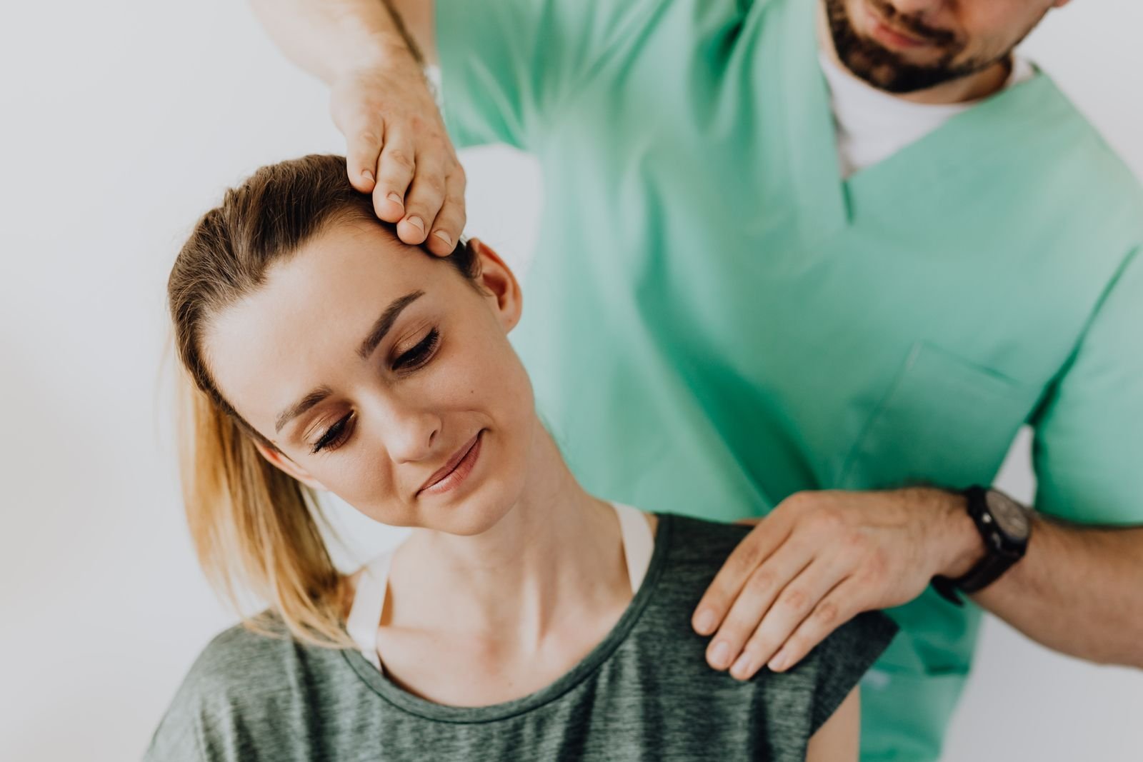 A chiropractor gently treating a smiling patient