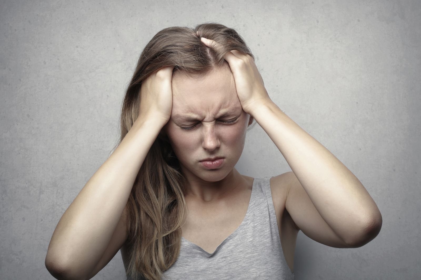 A woman at home holding her head in pain